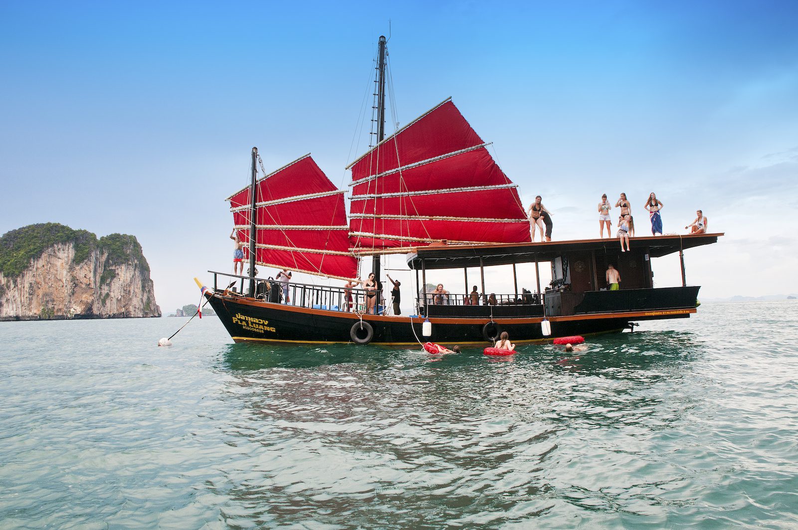 Invitados a bordo del barco Krabi Sunset Cruise Pla Luang y en el mar con islas al fondo