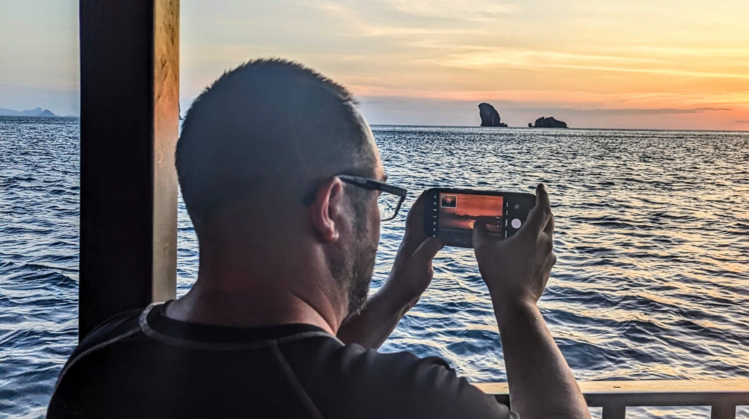 hombre haciendo una foto de una puesta de sol con su teléfono