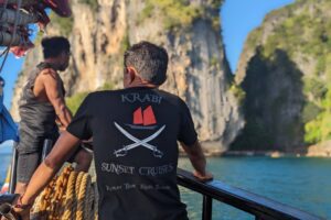 krabi sunset cruises crew looking out to the limestone cliffs from the boat