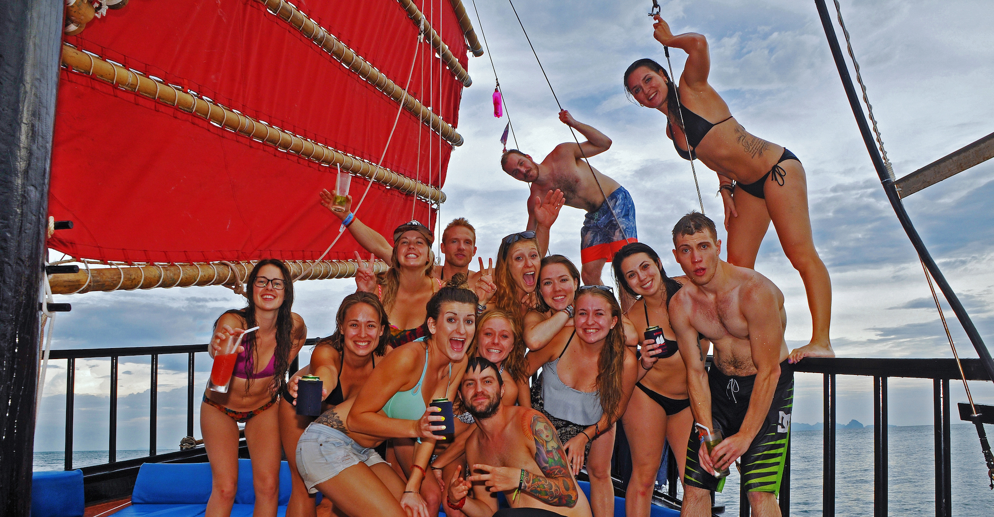 Foto de grupo de personas en una excursión en velero por Krabi con la vela roja más grande del barco a la izquierda