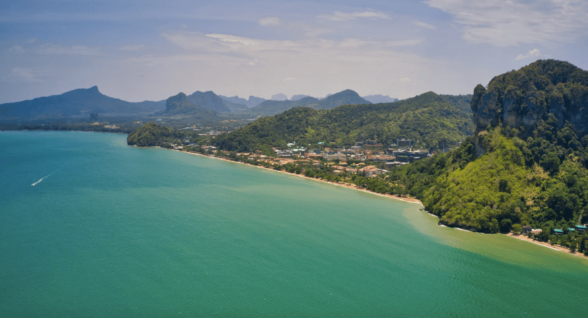 Drone photograph looking along the beach of AoNang, surrounded by mountians