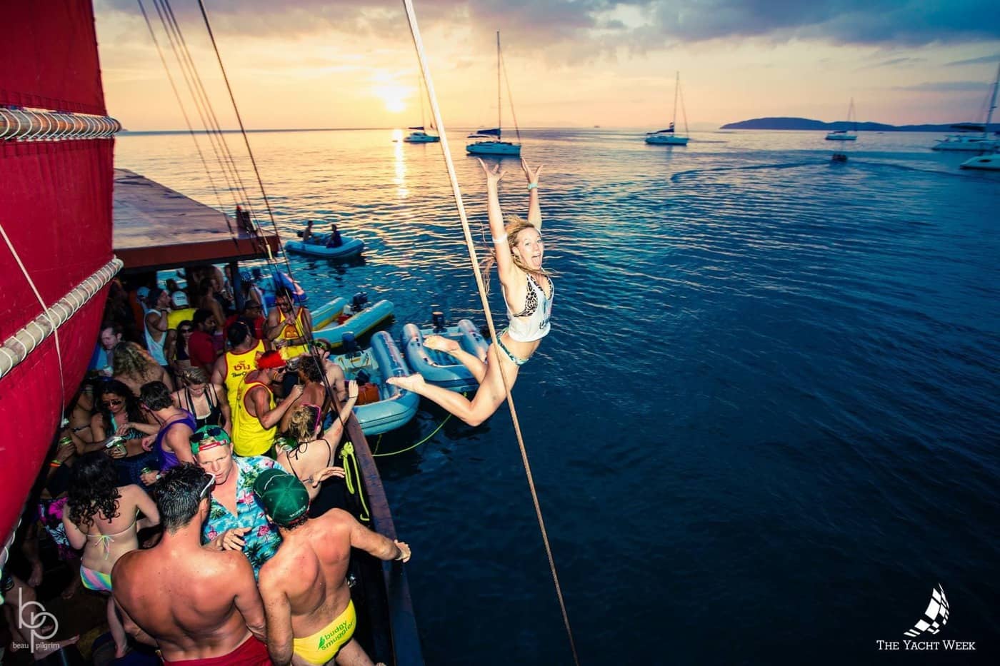Des invités profitent d'une fête animée en bateau privé au coucher du soleil, à bord d'une embarcation traditionnelle à Krabi.