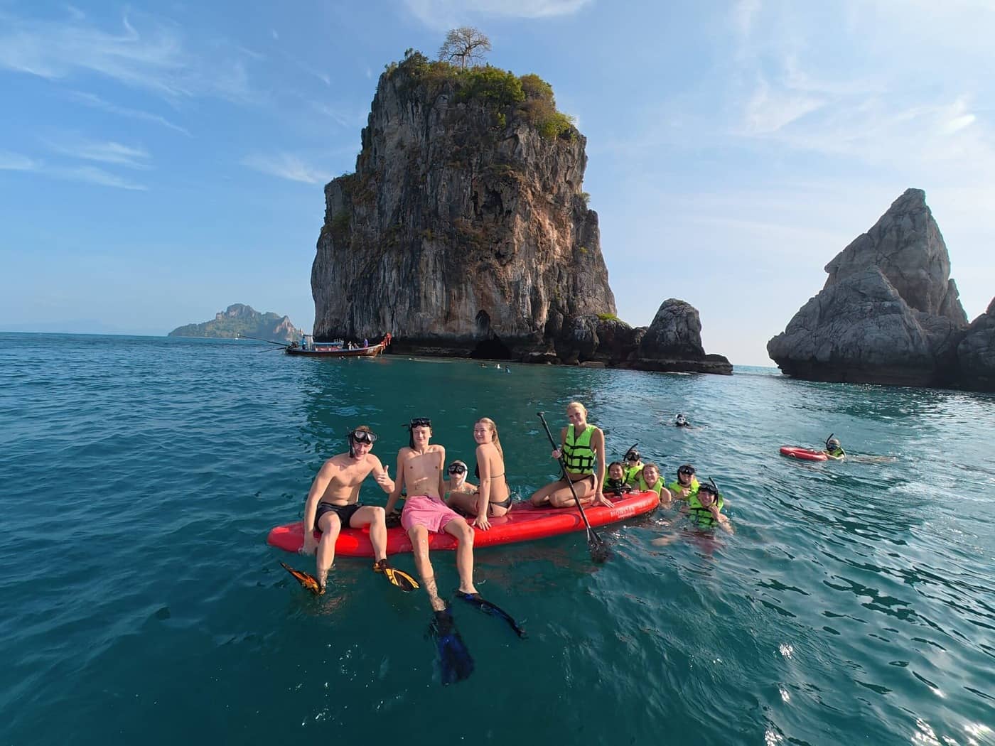 Baignade en groupe et moment de détente sur un paddleboard au large des spectaculaires îles calcaires de Krabi.