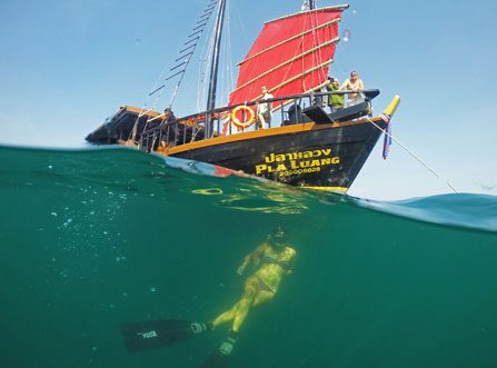 Underwater image of guest snorkling underneath The Pla Luang Boat at Krabi Sunset Cruises