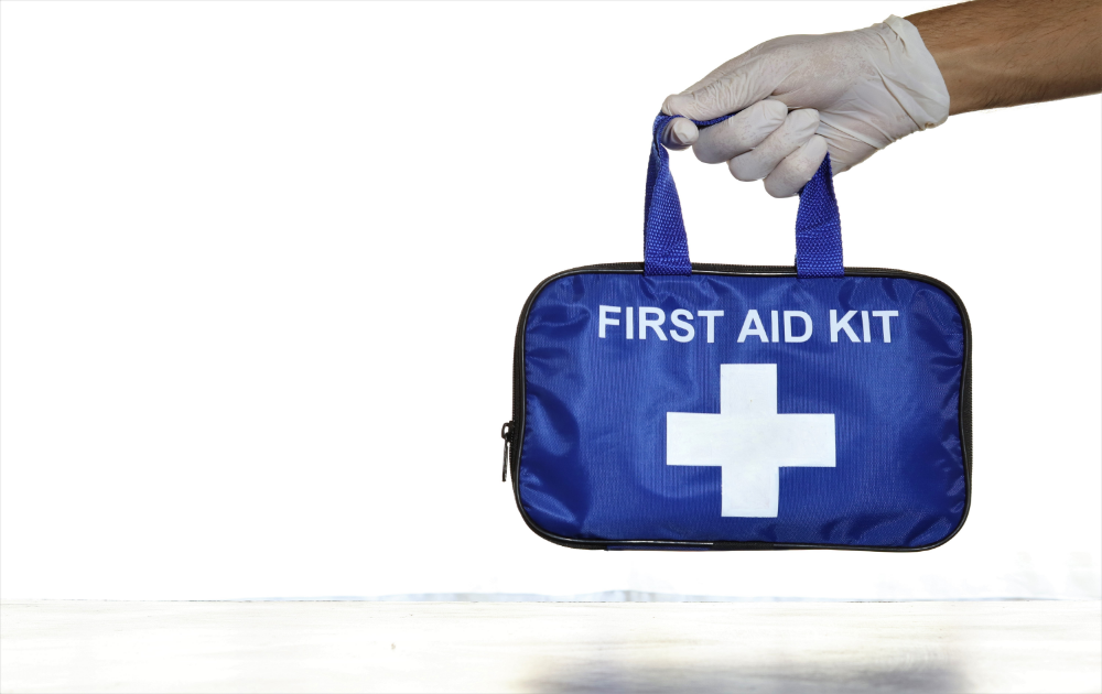 main tenant une trousse de premiers secours bleue