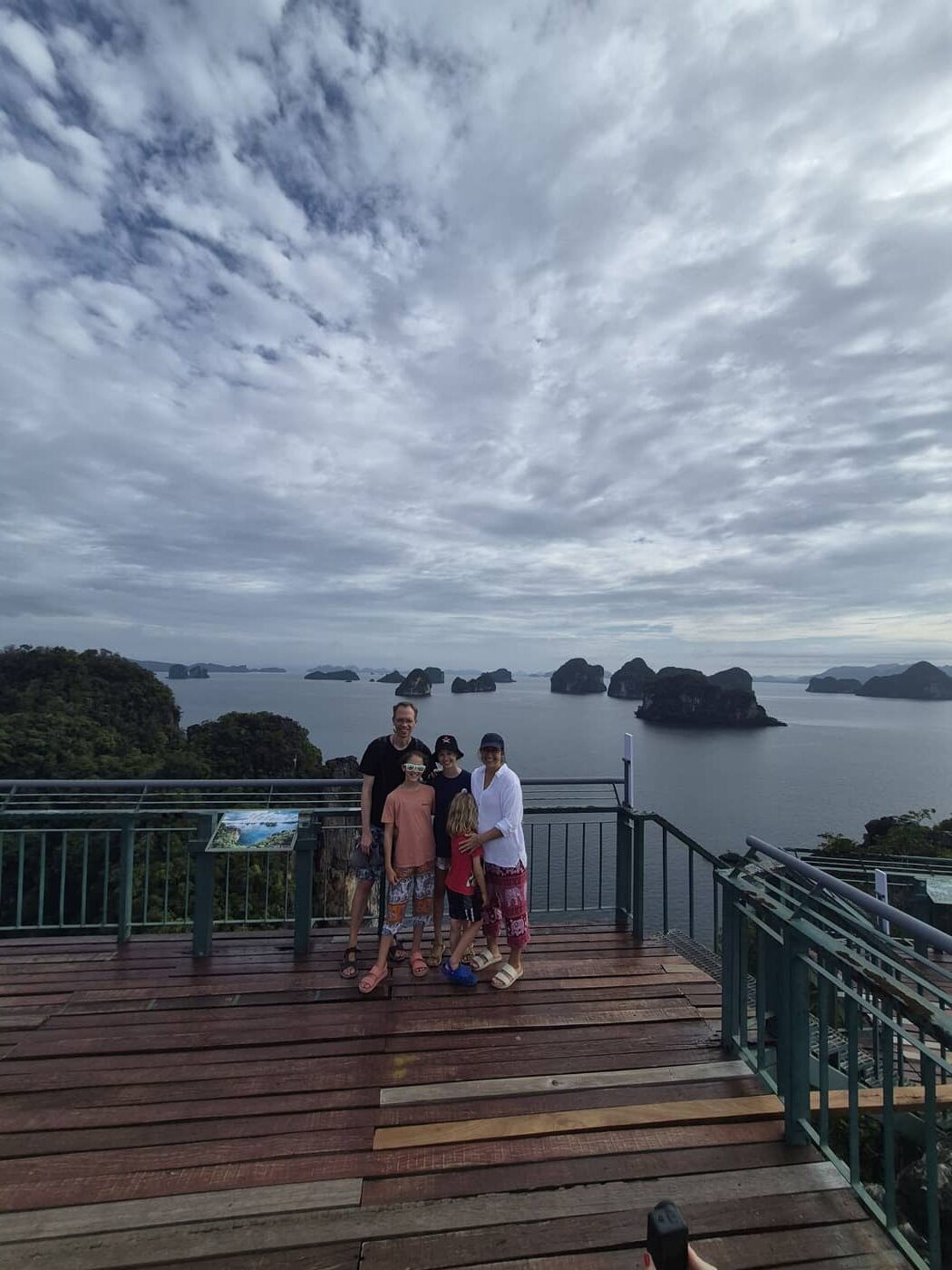 Una familia en lo alto del mirador de Hong Islands, con las islas a lo lejos