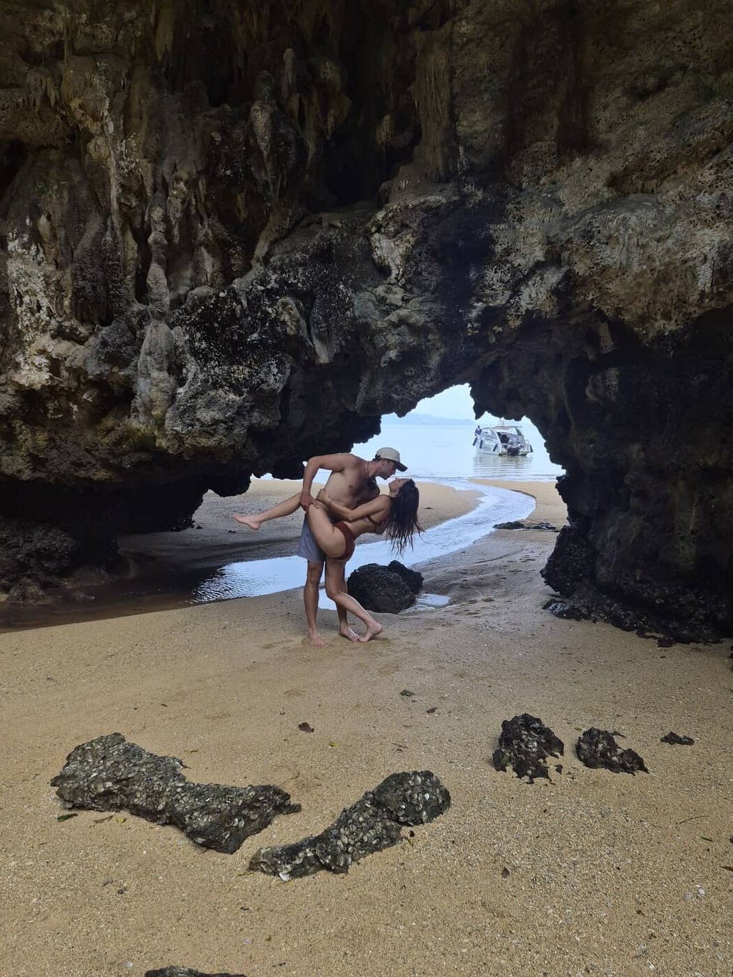Pareja posando delante de la entrada de una cueva en Krabi