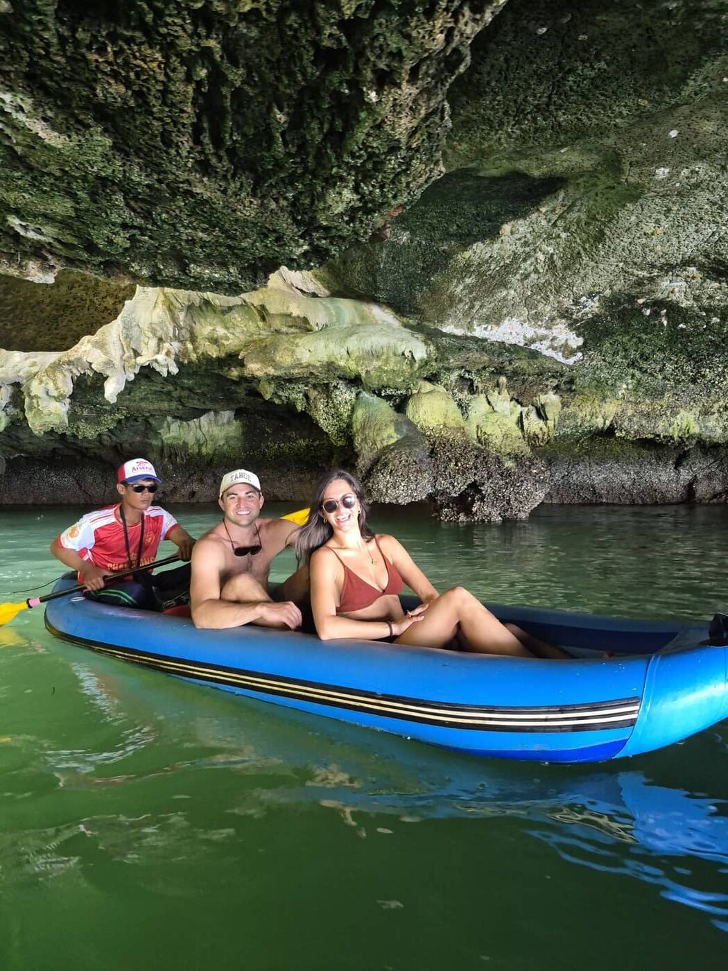 Huéspedes practicando kayak con un guía local bajo los acantilados de piedra caliza de la bahía de Phang Nga