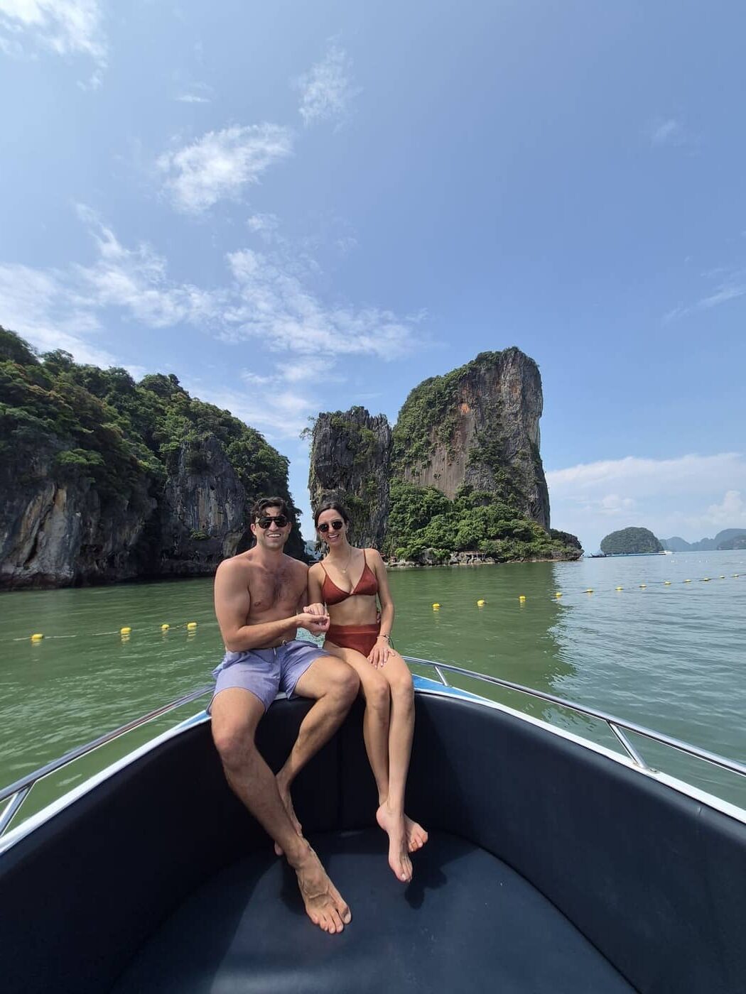 Turistas contemplando la isla de James Bond desde la lancha motora en la bahía de Phang Nga