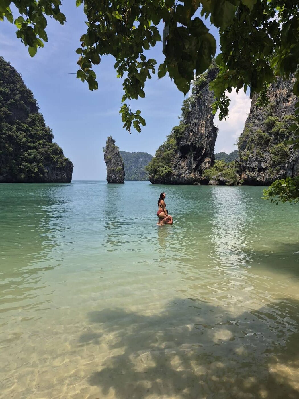 Pareja nadando en una playa poco concurrida de Krabi, rodeada de acantilados de piedra caliza