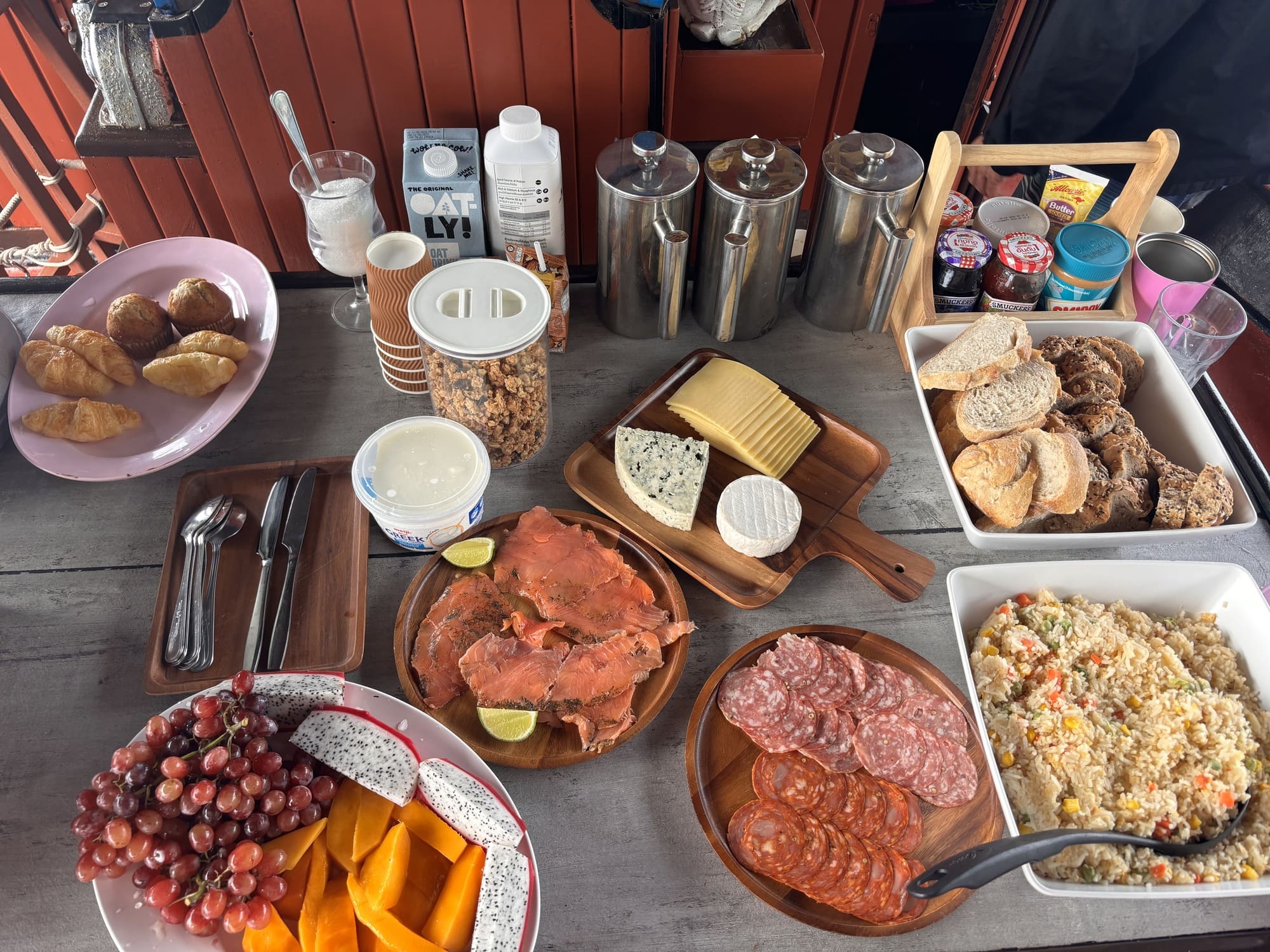 Gourmet breakfast spread with pastries, smoked salmon, cheeses, fruit, bread and coffee served aboard the boat.