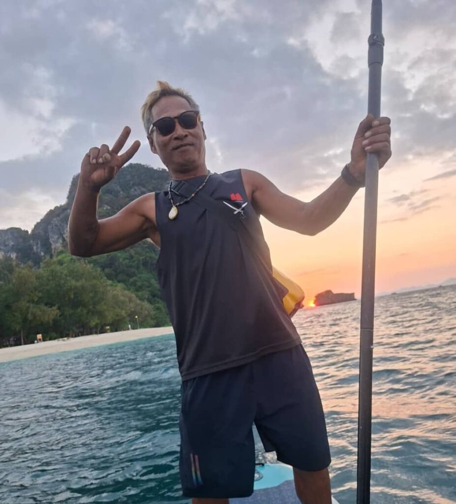 El capitán de Krabi Sunset Cruises sobre una tabla de paddle surf en la isla de Poda